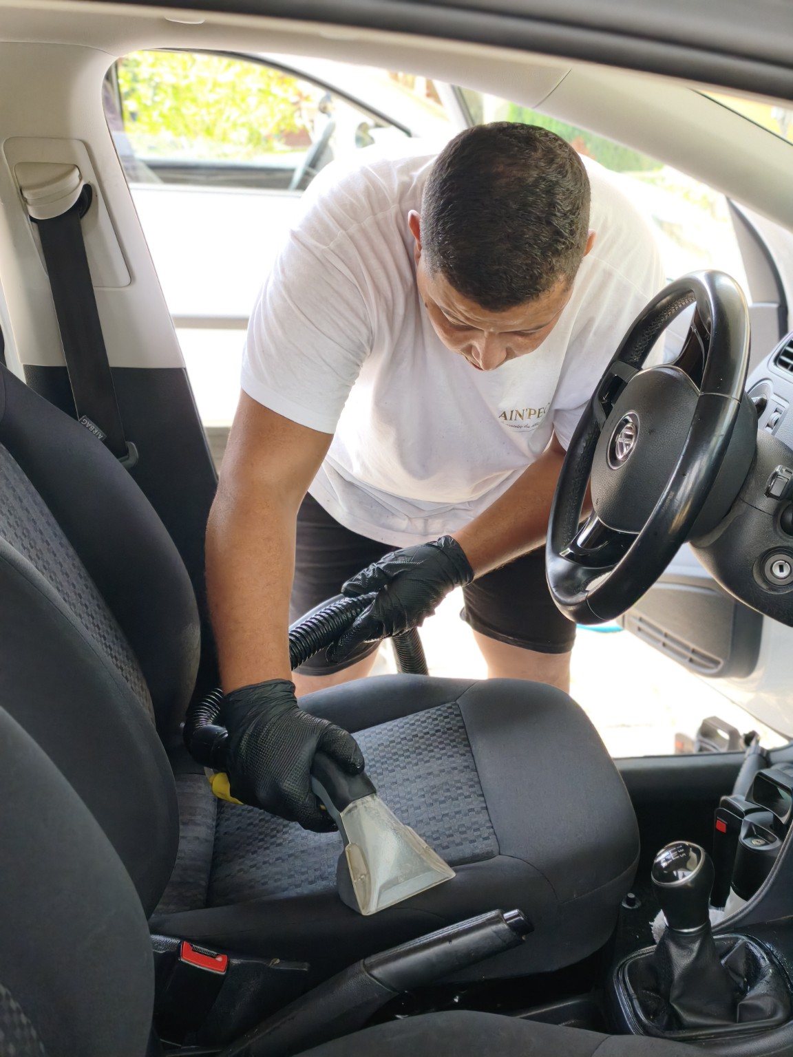 Adam d'AIN'PEC pendant un nettoyage automobile
